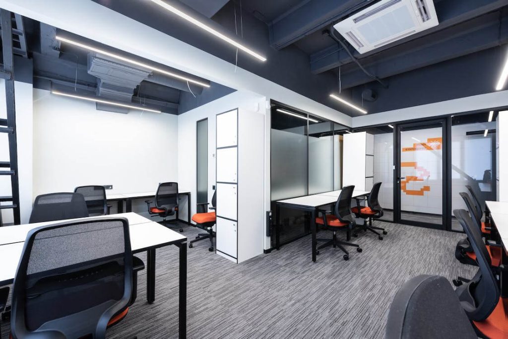 open office space with filing cabinets and multiple workstations each with an ergonomic desk chair