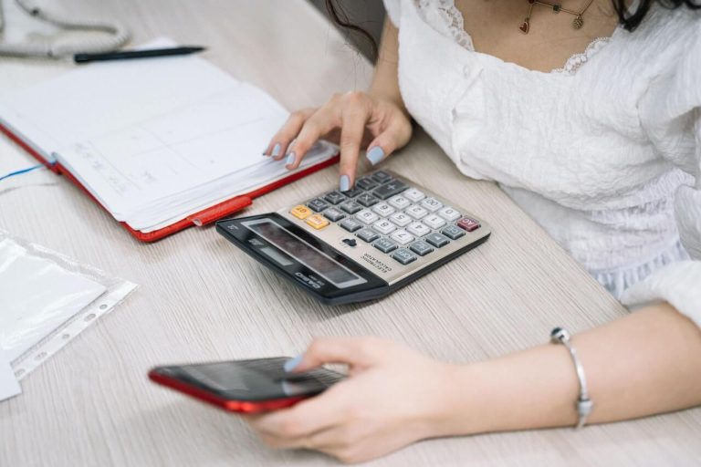 woman doing accounting with phone and calculator